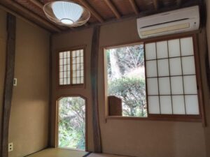 障子窓やにじり口が開き、外の鮮やかな緑が美しく覗くカット